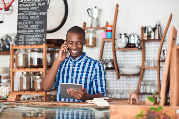 istock Smiling young African entrepreneur busy working in his cafe 2181005591