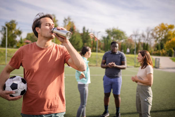 istock Man drinks water, preparing for soccer field practice. 2181006683