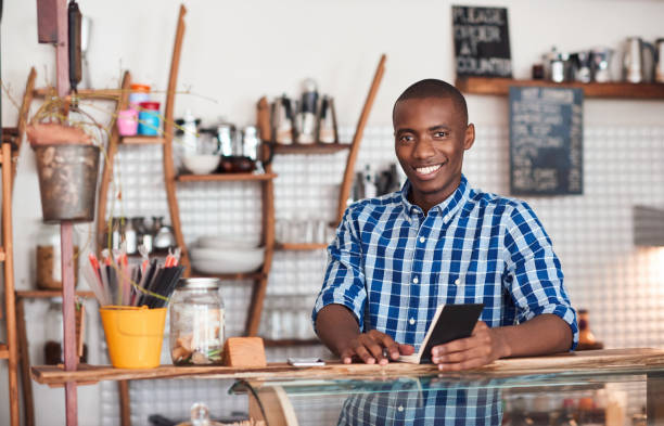 istock Smiling young African entrepreneur working in his cafe 2181006892