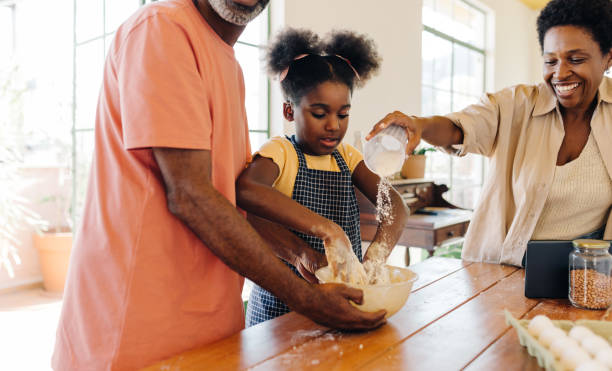 istock Baking in the kitchen: A family making a delicious cake 2181007489