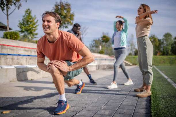 istock Man lunges energetically as others stretch nearby. 2181007598
