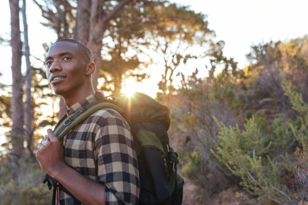 istock Young African man hiking alone in the wilderness at dusk 2181008629