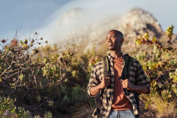 Smiling young African man out for a mountain hike