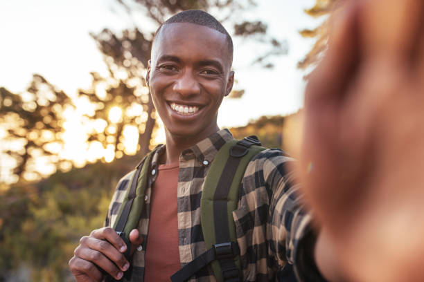 istock Smiling young African man taking selfies while out hiking 2181008819