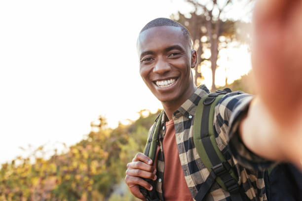 istock Smiling young African man taking a selfie while hiking outdoors 2181009164