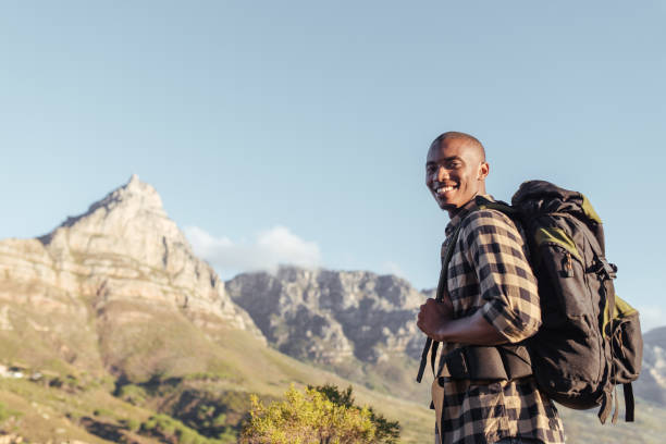 istock Smiling young African man enjoying the view while out hiking 2181010170