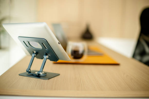A tablet on a stand is located on a wooden office desk, providing a tech-savvy and organized environment that promotes modern work efficiency and clarity.