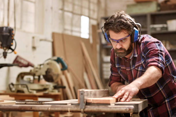 istock Carpenter working with machinery cutting a wooden plank 2181015043