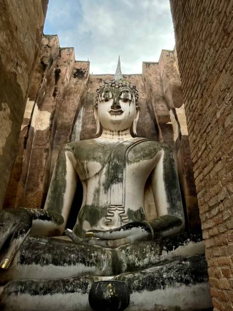 Thailand - Sukhothai - Wat Si Chum. Wat Si Chum is remarkable for its huge sitting Buddha covered with stucco. This is the largest of this type in Thailand. It is 15 meters high. An opening in the front wall allows you to discover it long before entering the building that houses it.