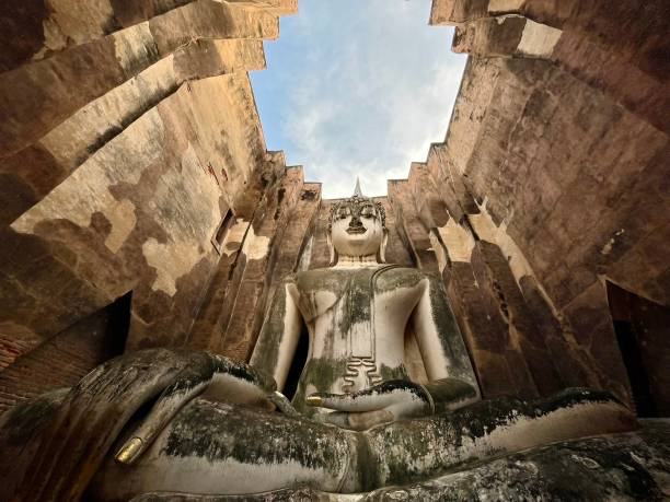 Thailand - Sukhothai - Wat Si Chum. Wat Si Chum is remarkable for its huge sitting Buddha covered with stucco. This is the largest of this type in Thailand. It is 15 meters high. An opening in the front wall allows you to discover it long before entering the building that houses it.