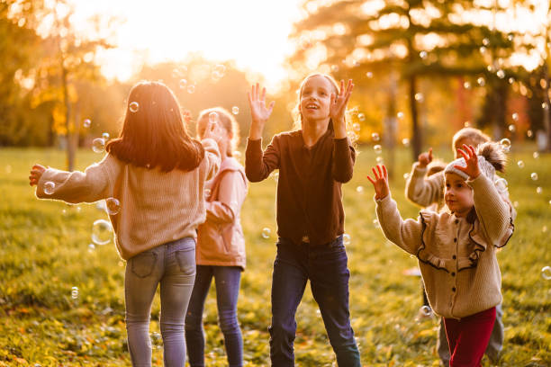 istock Children have fun catching bubbles in the park 2181016448