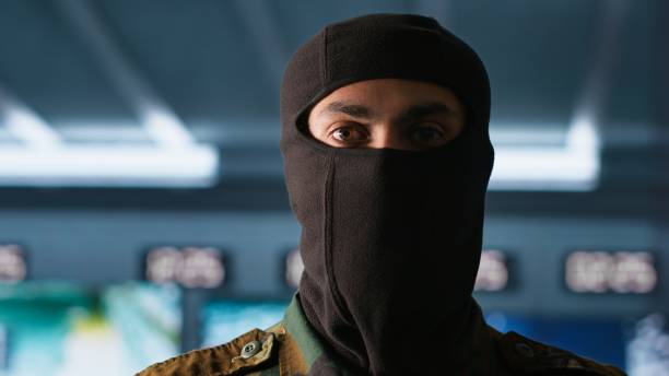 istock Portrait of terrorist loading gun, attacking enemy command center, close up 2181018580