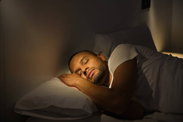 istock Young man sleeping peacefully in his bed at night 2181023529