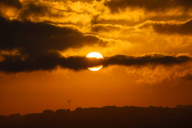 The sun rises over Jerusalem, Israel, on a partially cloudy morning.