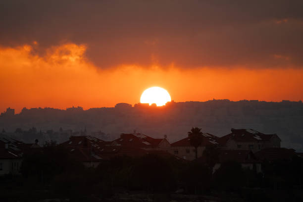 The sun rises over Jerusalem, Israel, on a partially cloudy morning.