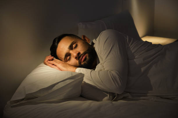 Young man sleeping peacefully in his bed at night