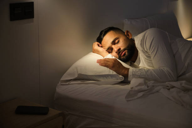 istock Young man sleeping peacefully in bed at night 2181023789