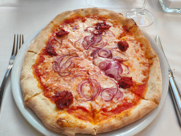 Close-up shot of Italian pizza with tomato sauce, mozarella cheese, onion and chilli paste. concept:  Pizza Cipolla / Pizza alle Cipolle