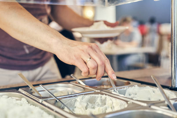 istock Self-service canteen in the office center. A man's hand dials white sauce into a plate. A variety of sauces on a metal tray with space for copying 2181031077