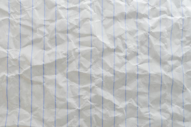 Crumpled notebook paper background with blue lines, perfect for text and design projects requiring a textured surface.