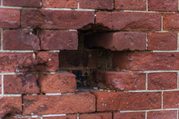 istock A hole in the red brick wall. A cross in a brick wall The dilapidated brick wall 2181036900