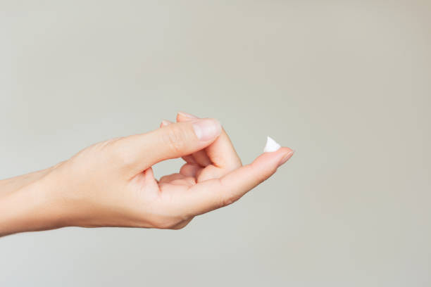 istock A young woman's hand holding a drop of white moisturizing cream on her index finger. 2181037040