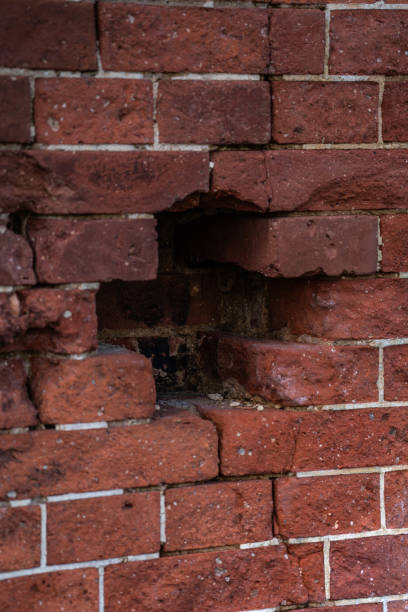 istock A hole in the red brick wall. A cross in a brick wall The dilapidated brick wall 2181037143