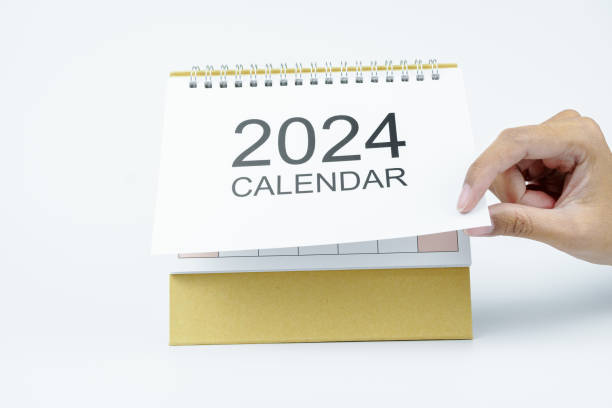 istock woman hand open 2024 calendar on white background 2181038904