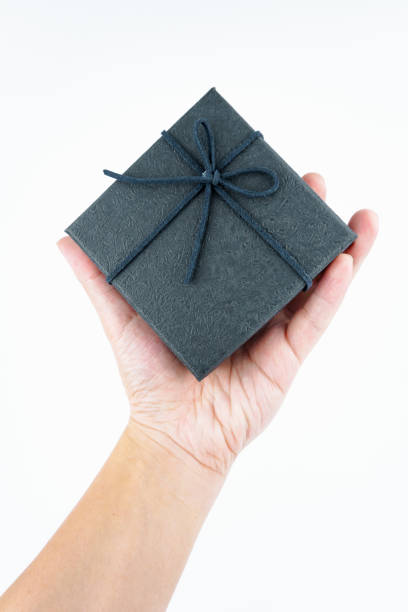 istock Hand holding black gift box on white background. 2181039044