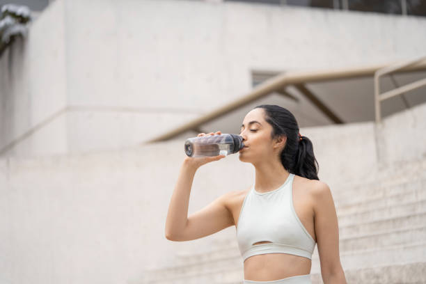 istock A women drinks water after exercising 2181041729