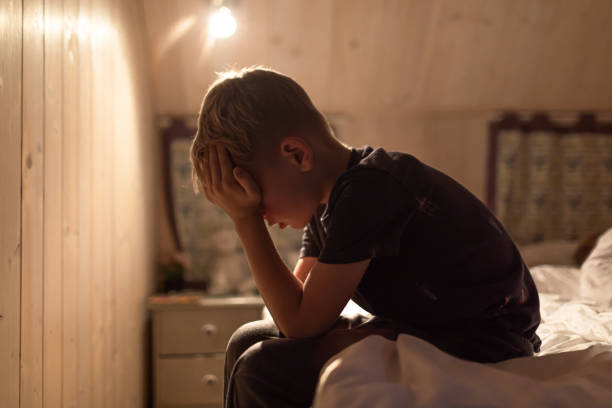 A young man sitting alone, hugging his knees, portraying emotional struggle and sadness. This image represents mental health challenges, depression, and the need for support and awareness.