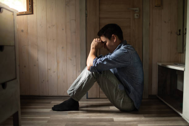 istock Unhappy man hand over face, sitting on floor at home, thinking about problems, upset person feeling lonely and sad, psychological and mental troubles, suffering from bad relationship or break up. 2181046936