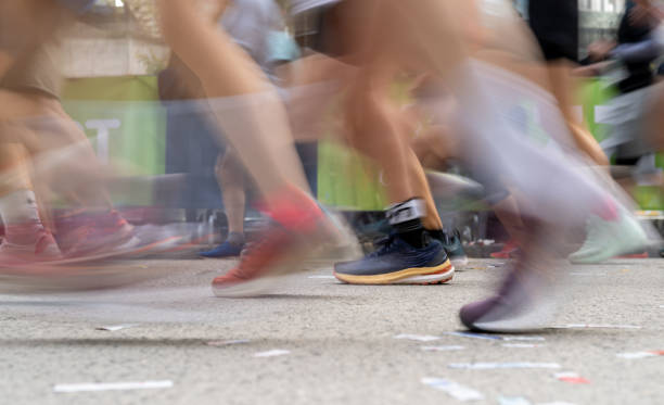Long exposure photo and close up to the feet of the runners in a real Marathon. and space in the lower part for text.