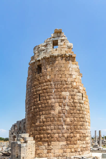 Stone gate tower at Perge ancient city ruins under clear blue sky, a glimpse into Roman history. Antalya, Turkey (Turkiye)