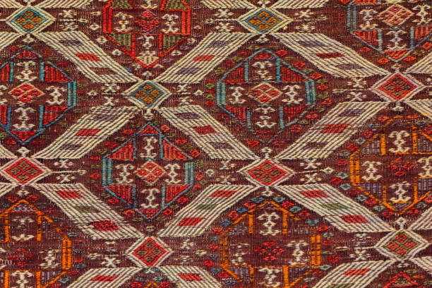 Old Turkish carpet, geometric and tribal patterns in red, white, and dark tones, decor and cultural themes. Istanbul, Turkiye (Turkey)