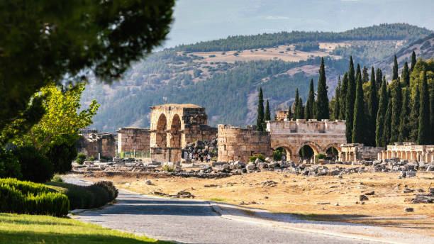 Hierapolis ruins framed by nature with mountains backdrop. Pamukkale, Denizli, Turkey (Turkiye)