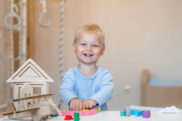 istock A little boy of 2 years old is playing a developing logistics constructor. Children's wooden toys. Montessori for child development. 2181055151