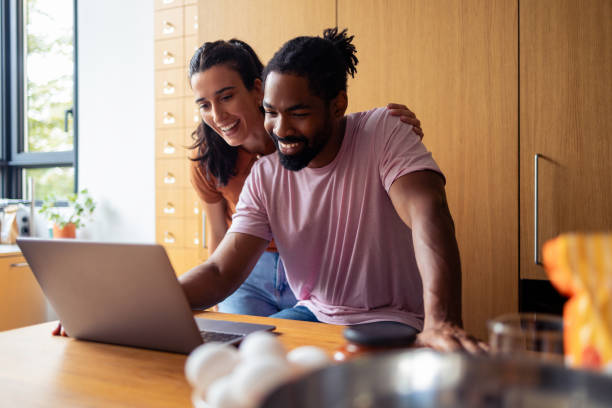 istock Happy Couple Enjoying Time Together While Using Laptop at Home 2181058124