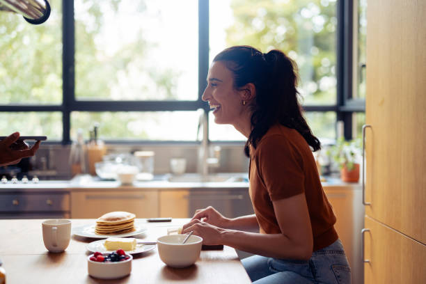 Woman Enjoying Pancake Breakfast in a Bright Modern Kitchen