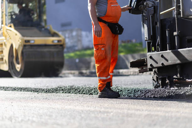 istock Construction worker operating asphalt paver on a road in urban area during daylight hours with heavy machinery in background 2181059502