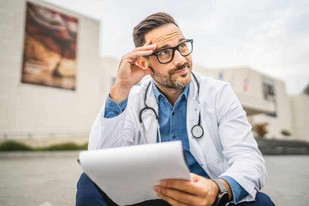 istock exhausted worried doctor read information from clipboard 2181062948