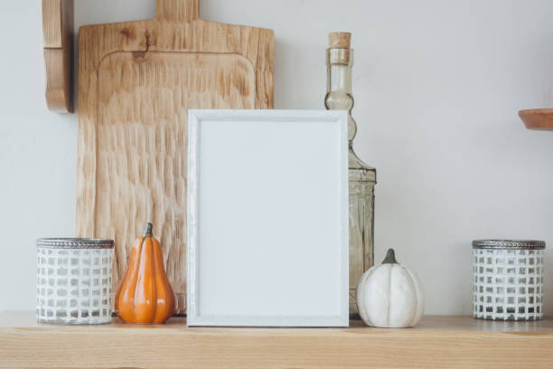 istock Autumn kitchen decor featuring pumpkins, candles, and a blank frame on a wooden countertop 2181074749