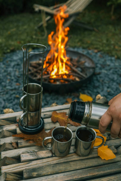 istock Themed trip. The man pours a hot drink into the thermos 2181080786