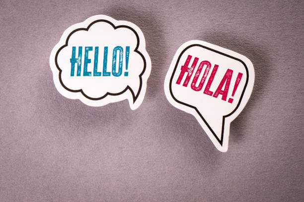 istock Hello in English and Spanish. Two speech bubbles on a gray background 2181080894