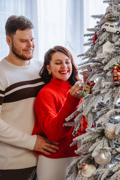 istock couple together decorating christmas tree 2181081281