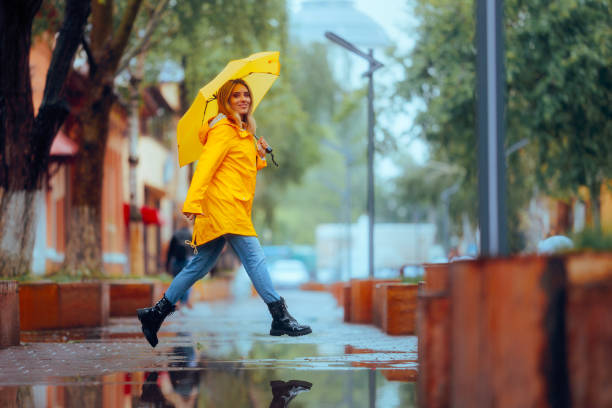 Cheerful lady running in the city in a rainy day