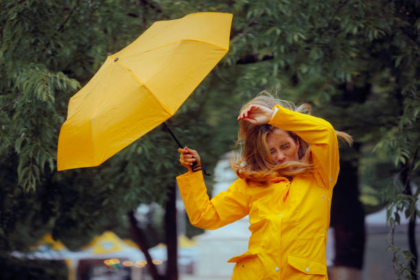 Woman in Discomfort from Wind During a Rainstorm Tempest stock photo