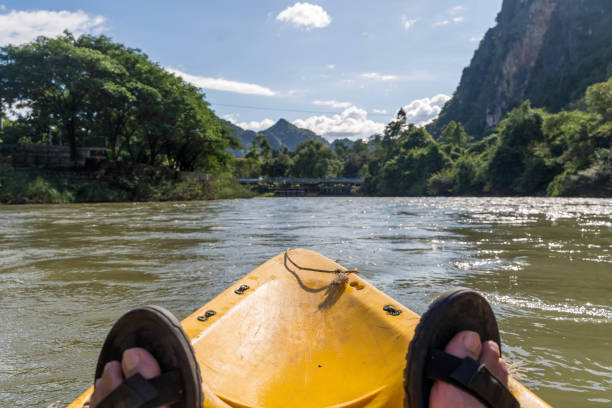 istock A person is sitting in a yellow kayak on a river. 2181084257