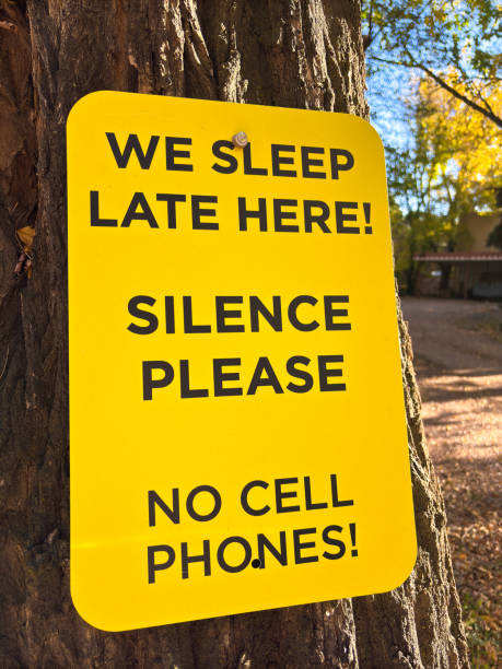 istock Sign Reading: WE SLEEP LATE HERE NO CELL PHONES! 2181091994