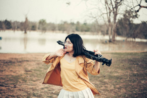 Woman taking photos with a vintage camera in park.